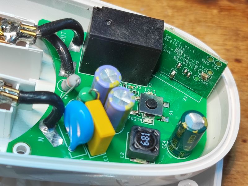 Wnętrze inteligentnej wtyczki Sonoff S26R2ZB z modułem Zigbee i elementami elektronicznymi.