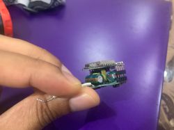 Electronic Module with Capacitors Person holding a small electronic module with visible capacitors.