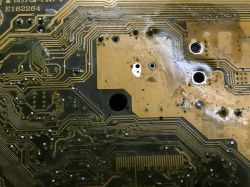 Close-up of a computer motherboard with visible traces and holes.