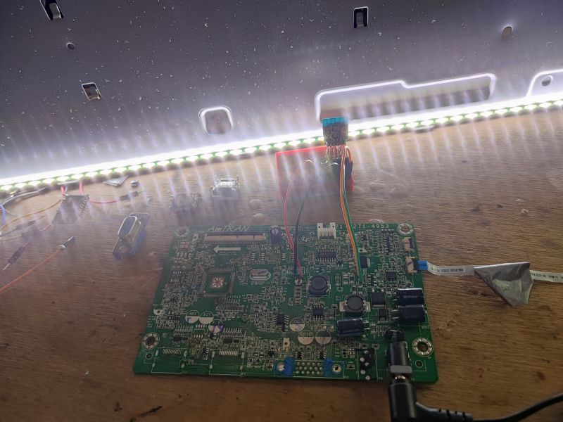 PCB with WiFi Module and LED Strip PCB with WiFi module connected to LED strip on a workbench.