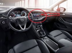 Wnętrze samochodu Opel z widokiem na kierownicę i ekran dotykowy.