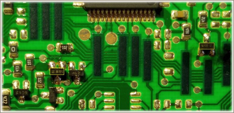 Zbliżenie na zieloną płytkę drukowaną z widocznymi komponentami elektronicznymi.