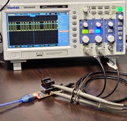 Close-up of Hantek oscilloscope with signal waves and connected CH341 programmer