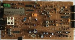 Widok płytki drukowanej z elementami elektronicznymi, w tym układami scalonymi, kondensatorami i złączami.