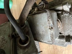 Zbliżenie na zakurzoną metalową skrzynkę elektryczną z kablami wychodzącymi z gniazd.