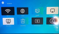 Ekran menu ustawień Smart TV Android Box z ikonami opcji, takie jak Wi-Fi, Język, i Tapeta.
