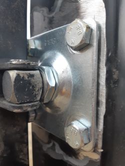 Zbliżenie na metalową konstrukcję z śrubami mocującymi.