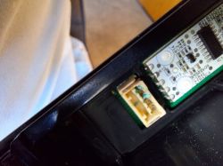 Zbliżenie na panel elektroniczny z widocznymi śladami wilgoci na złączu.