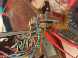 Zbliżenie na płytkę PCB z przewodami i multimetr pokazujący 120.8