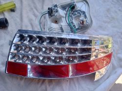 Rozmontowana lampa LED samochodowa z podłączeniami i odbłyśnikiem.