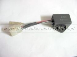 Czarny moduł elektroniczny z przewodami i białą wtyczką na jasnym tle