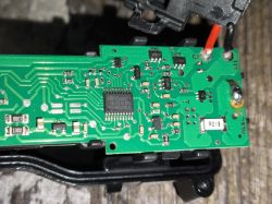 Zbliżenie na płytkę drukowaną z różnymi komponentami elektronicznymi.