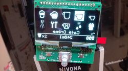 Anzeigedisplay des Bedienfelds einer Kaffeemaschine mit Symbolen und Text.