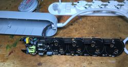 Disassembled Overmax Flow Multi Control Power Strip Interior of a disassembled power strip with four outlets and three USB ports.