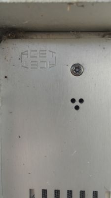ACET Metal Plate with Holes and Screw Close-up view of a metal plate with the inscription ACET and a screw.