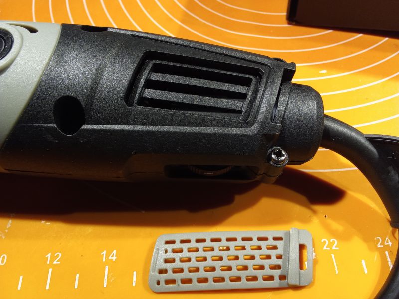 Zbliżenie na czarną szlifierkę z wyjmowaną kratką chłodzenia, zdejmowaną z boku urządzenia.