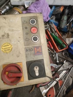 Panel sterujący Hormann A50 z elementami sterującymi i narzędziami w tle.