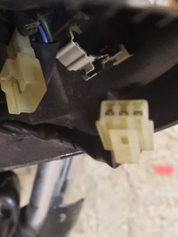 Zbliżenie na żółtą wtyczkę elektryczną z trzema pinami w motocyklu Yamaha XVS.