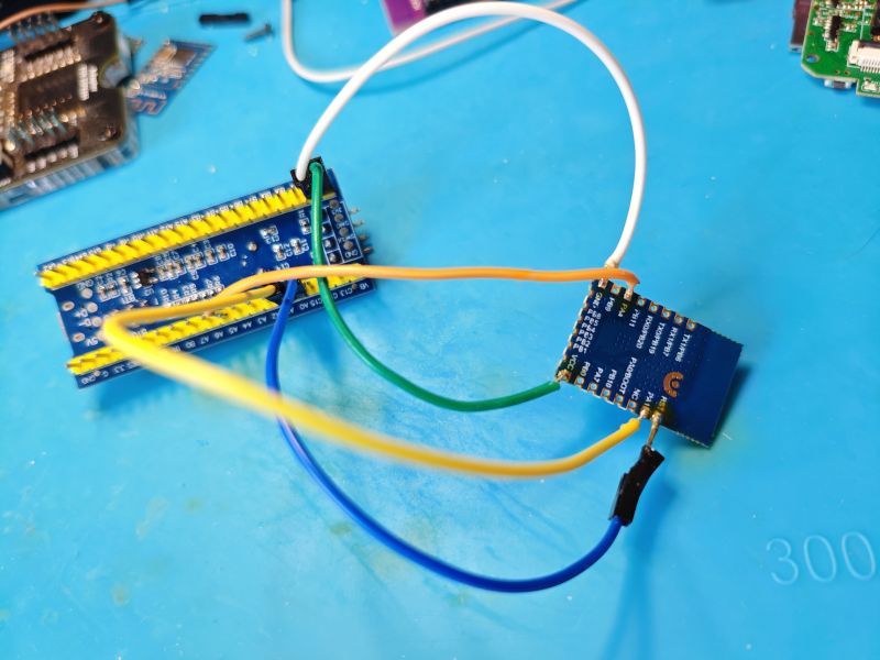 Two electronic modules connected with wires on a blue service mat.
