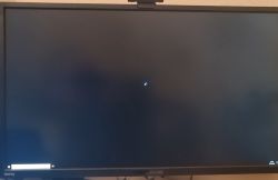 Czarny ekran z kursorem i kręcącym się kółeczkiem na monitorze komputera.