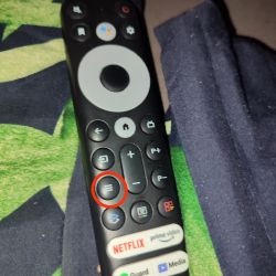 Zbliżenie na pilot TCL z zaznaczonym przyciskiem menu, który nie działa