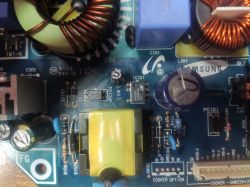 Zbliżenie na płytę elektroniki z elementami kondensatorów, transformatorów i zwojów.