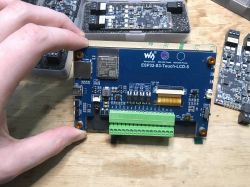 ESP32-S3-Touch-LCD-5 module held by a hand.