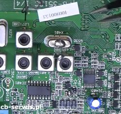 Zbliżenie na płytę główną z widocznym kwarcem i elementami elektronicznymi, oraz śladami lutowania.