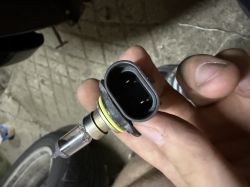 Zbliżenie na złącze elektryczne lampy przeciwmgielnej BMW trzymane w dłoni