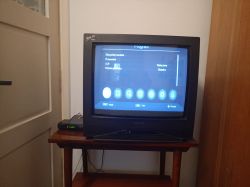 Stary telewizor kineskopowy wyświetlający menu z obciętym obrazem na górze i czarnym paskiem na dole.