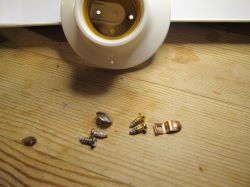 Mounting Components on a Table Mounting parts on a wooden table, including a light bulb holder, screws, and a metal bracket.