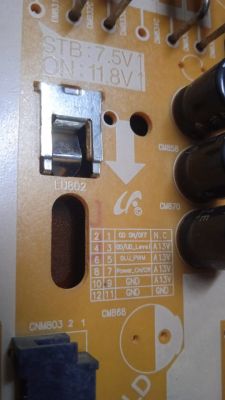 Close-up of a power supply board with voltage and component markings.
