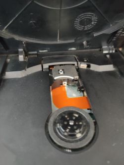 Wnętrze napędu optycznego z widoczną soczewką laserową i mechanizmem.