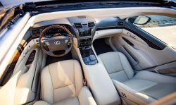 Wnętrze luksusowego samochodu Lexus z beżową skórzaną tapicerką i drewnianymi wstawkami, widok z góry.