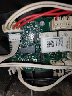 Zbliżenie na płytkę drukowaną ekspresu DeLonghi z widocznymi przewodami i komponentami elektronicznymi