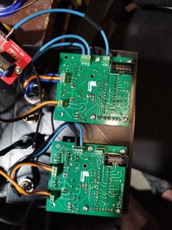 Dwa zielone moduły PCB połączone przewodami, zamontowane w czarnej obudowie