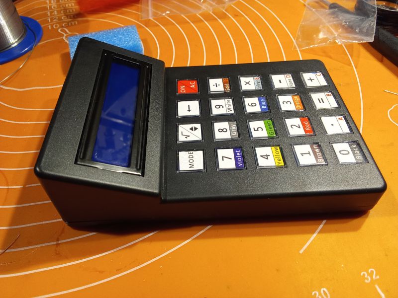 Kalkulator elektroniczny z wyświetlaczem LCD i kolorowymi przyciskami.