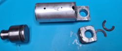 Uszkodzony cylinder i tłok z młotowiertarki Parkside PBH 800 A1 na niebieskim tle