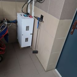 Biała obudowa magazynu energii zamontowana pionowo w narożniku na palecie.
