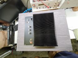Widok z góry na tylny panel subwoofera, z dużym radiatorem i złączami.