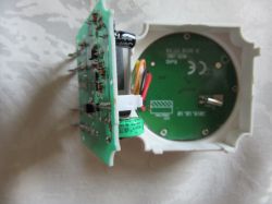 Urządzenie elektroniczne z widocznym modułem i częścią zegarową połączone przewodami.