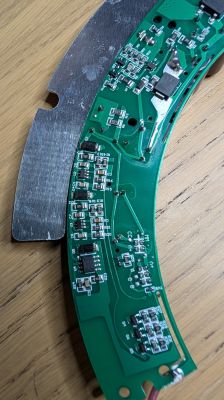 Curved PCB from LED lamp with electronic components and attached metal part