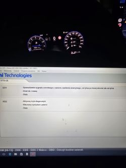 Zdjęcie zestawu wskaźników auta i ekranu laptopa z listą kodów usterek EBS/ABS