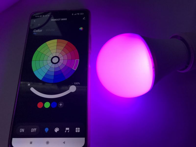 Pairing RGB/CCT Bulb with Tuya App Phone with Tuya app paired with a colorful RGB/CCT bulb glowing pink.