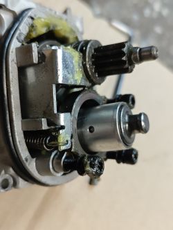 Wnętrze przekładni elektronarzędzia z zębatką, sprężyną i smarem w obudowie