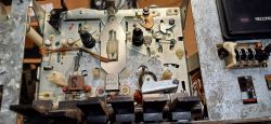 Wnętrze i mechanizm magnetofonu z widocznymi elementami metalowymi i plastikowymi.