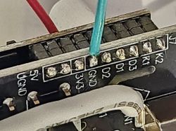 Close-up of an electronic connector with wires attached to the pins, with labels including 5V, GND, 3V3.