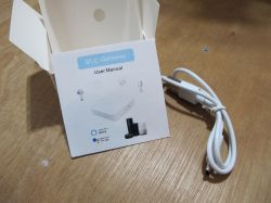Tuya BLE Gateway - User Manual and USB Cable Tuya BLE Gateway user manual with USB cable on a wooden surface.