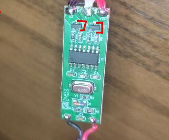 Zbliżenie na zieloną płytkę drukowaną z komponentami elektronicznymi.