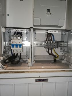 Szafa elektryczna z bezpiecznikami i przewodami.